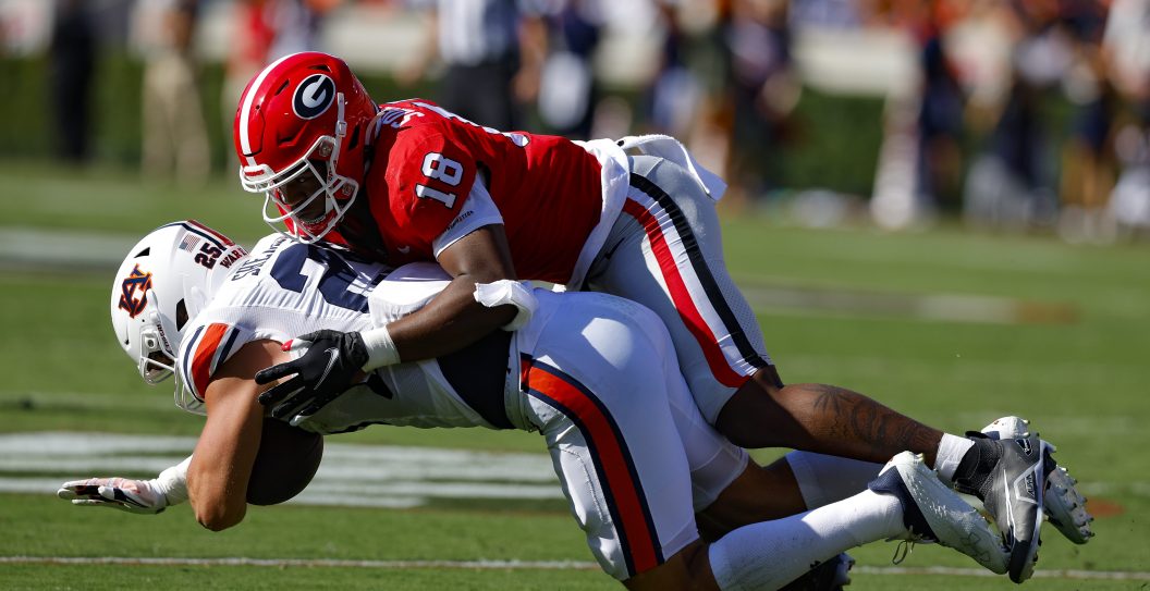 ATHENS, GA - OCTOBER 08: John Samuel Shenker #25 of the Auburn Tigers is tackled by Xavian Sorey Jr. #18 of the Georgia Bulldogs in the first half at Sanford Stadium on October 8, 2022 in Athens, Georgia.