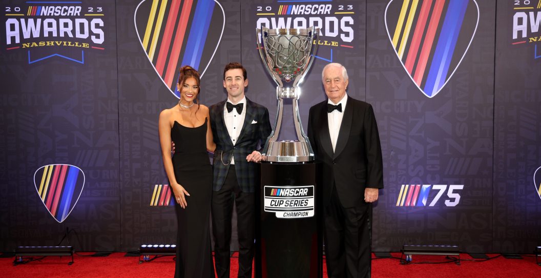 NASHVILLE, TENNESSEE - NOVEMBER 30: 2023 NASCAR Cup Series Champion, Ryan Blaney, Gianna Tulio and team owner, Roger Penske of Team Penske pose for photos on the red carpet next to the Bill France NASCAR Cup Series Championship trophy prior to the NASCAR Awards and Champion Celebration at the Music City Center on November 30, 2023 in Nashville, Tennessee.