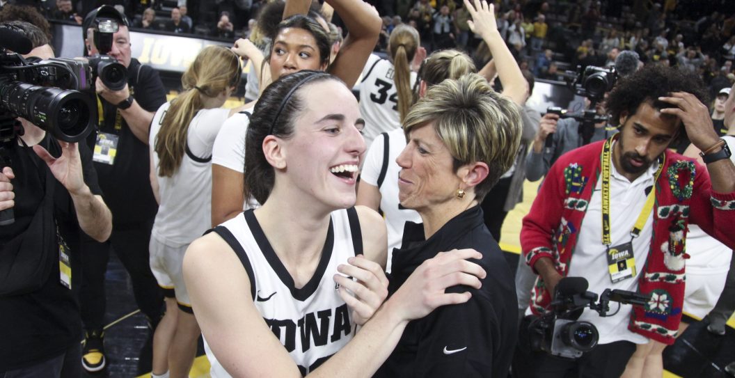 IOWA CITY, IOWA- DECEMBER 21: Guard Caitlin Clark #22 of the Iowa Hawkeyes celebrates with associate head coach Jan Jensen after the game against the Loyola-Chicago Ramblers at Carver-Hawkeye Arena on December 21, 2023 in Iowa City, Iowa.