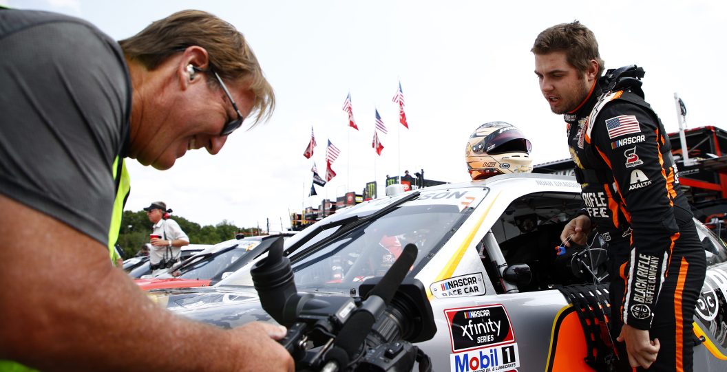 ELKHART LAKE, WISCONSIN - JULY 02: Noah Gragson, driver of the #9 Bass Pro Shops/TrueTimber/BRCC Chevrolet, interacts with a cameraman during practice for the NASCAR Xfinity Series Henry 180 at Road America on July 02, 2021 in Elkhart Lake, Wisconsin.