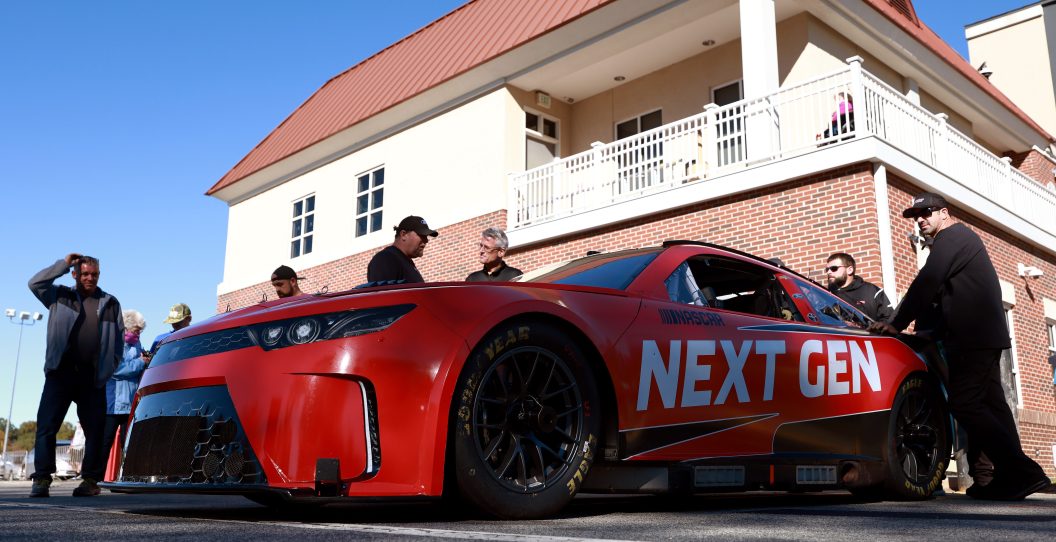 WINSTON SALEM, NORTH CAROLINA - OCTOBER 26: Crew members wait to push the NASCAR Next Gen test car back to its hauler after a session at Bowman Gray Stadium on October 26, 2021 in Winston Salem, North Carolina.