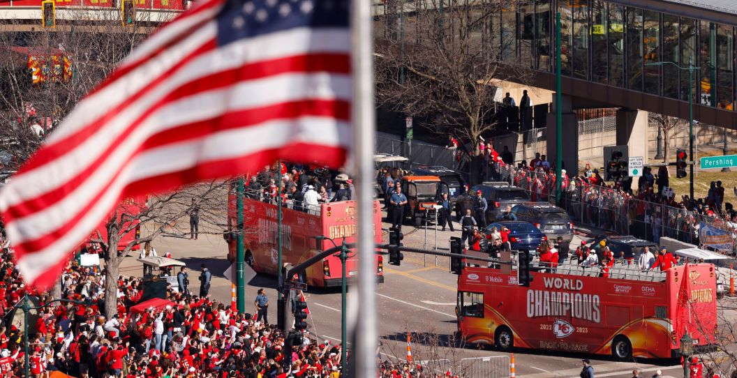 A photo from the Chiefs Super Bowl parade shows buses and an American flag.