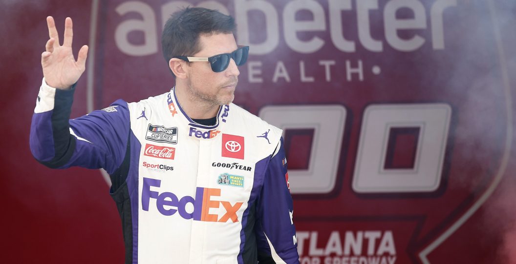 HAMPTON, GEORGIA - FEBRUARY 25: Denny Hamlin, driver of the #11 FedEx Toyota, waves to fans as he walks onstage during driver intros prior to the NASCAR Cup Series Ambetter Health 400 at Atlanta Motor Speedway on February 25, 2024 in Hampton, Georgia.