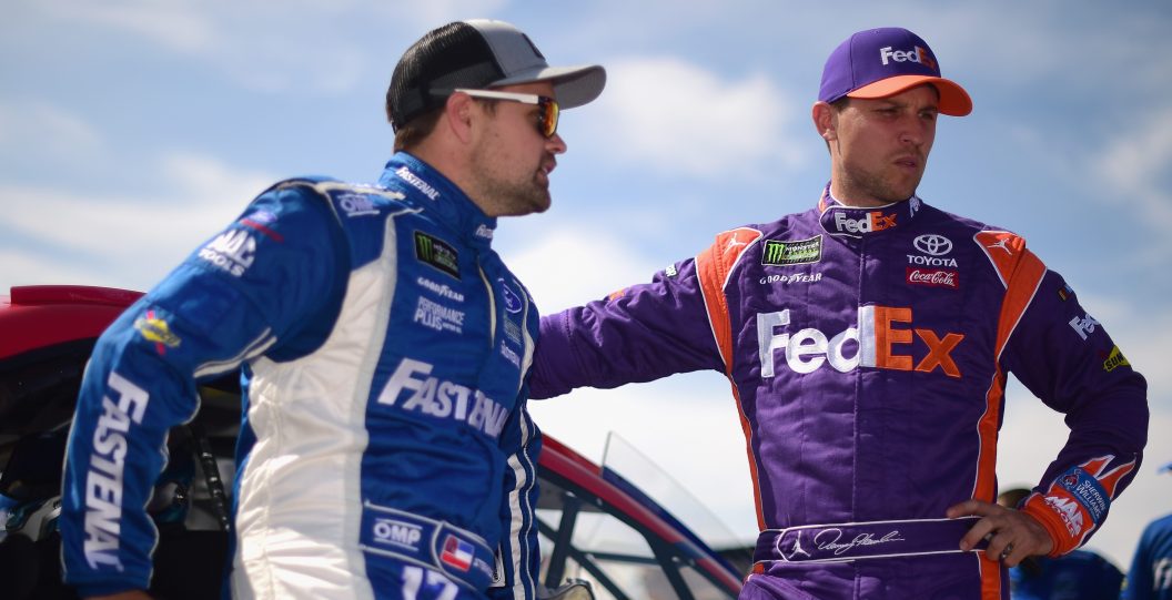 LONG POND, PA - JULY 28: Denny Hamlin, driver of the #11 FedEx Express Toyota, and Ricky Stenhouse Jr., driver of the #17 Ford Ford, stand on the grid during qualifying for the Monster Energy NASCAR Cup Series Gander Outdoors 400 at Pocono Raceway on July 28, 2018 in Long Pond, Pennsylvania.