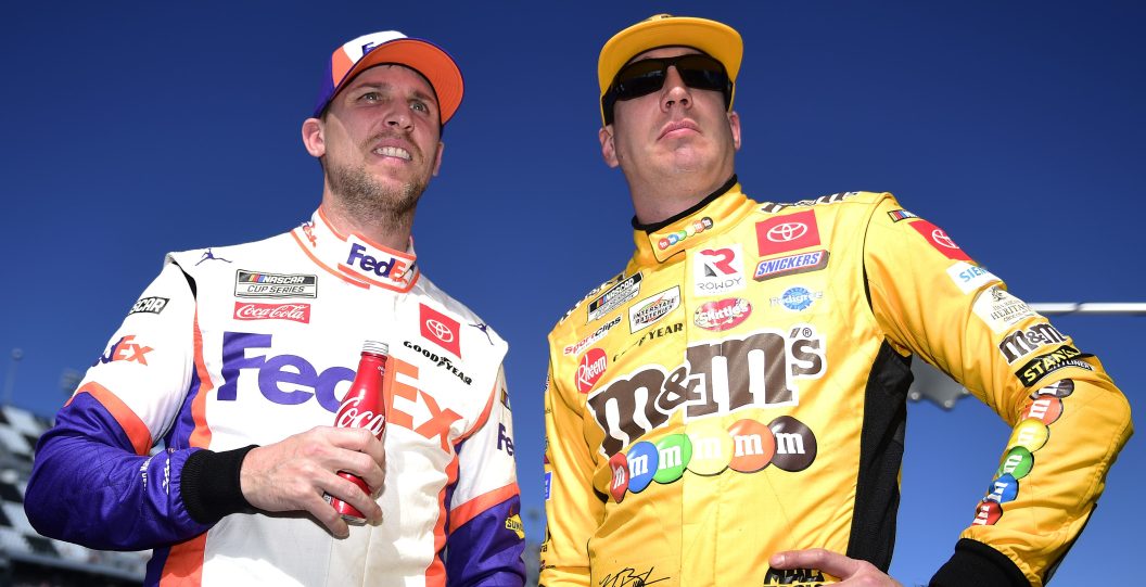 DAYTONA BEACH, FLORIDA - FEBRUARY 09: Kyle Busch, driver of the #18 M&M's Toyota, and Denny Hamlin, driver of the #11 FedEx Express Toyota, stand on the grid during qualifying for the NASCAR Cup Series 62nd Annual Daytona 500 at Daytona International Speedway on February 09, 2020 in Daytona Beach, Florida.
